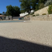 Terrasse avec piscine et mur en pierre.