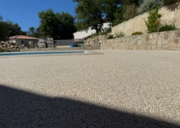 Terrasse avec piscine et mur en pierre.