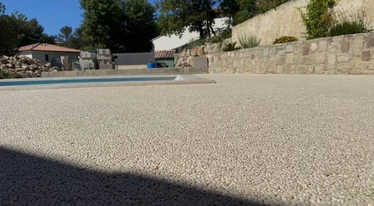 Terrasse avec piscine et mur en pierre.
