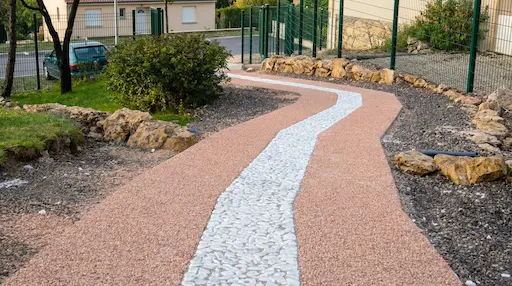 Allée de jardin en gravier et pierres blanches.